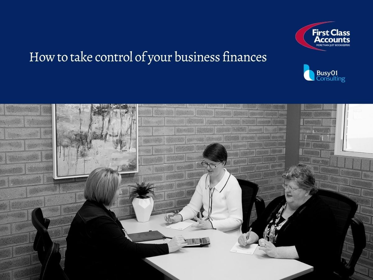 Three women meet around an office table to review business finances, with a calculator and paperwork, beneath First Class Accounts Ovens & Murray and Busy01 Consulting branding.
