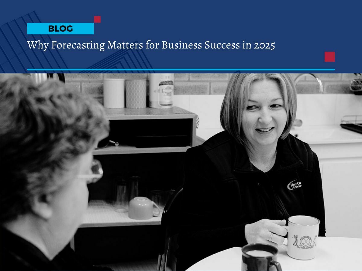 Business forecasting 2025-26 (1) Two women chatting over coffee in an office kitchen, with one wearing a First Class Accounts Ovens & Murray vest, supporting a blog about business forecasting in 2025-26.