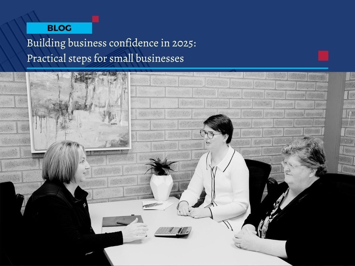 Three businesswomen in a meeting discussing bookkeeping and business confidence strategies for small businesses in 2025.